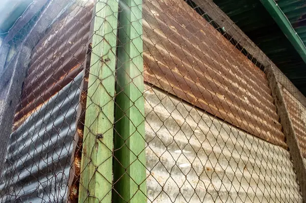 Üst üste binen paslı kıvrımlı metal katmanları, aşınmış ahşap ve tel örgüleri soyut bir endüstriyel doku oluşturur. Bir grunge veya eski estetik ile arka plan için idealdir