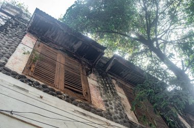 Sıkıntılı bir teneke çatısı ve süslü ızgaraların üzerindeki boyaları soyarak zengin bir tarih ve çürüme hissi veren yaşlı Creole tarzı bir cephe.