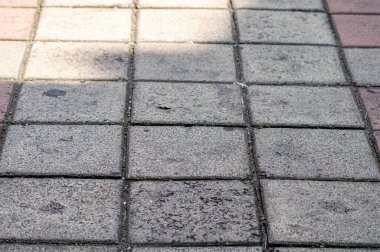 Gri beton kaldırımın yakın görüntüsü, desenli yüzeyi ve doğrusal desenini gösteriyor. arkaplan, kentsel sahneler, inşaat, patikalar veya dış döşeme ile ilgili kavramlar için
