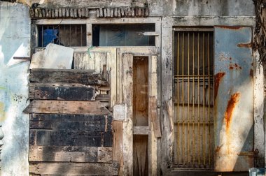 Harap olmuş ahşap kulübe kapısı, yıpranmış gecekondu mahallesi paslı metaller, eski iskeleler ve haşin güneş ışığıyla yıpranmış dokular.