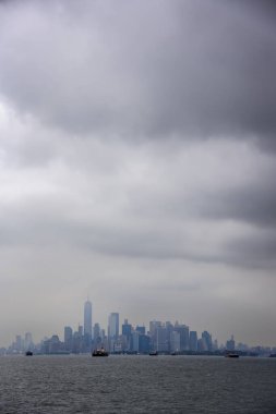 Manhattan Skyline bulutlu bir günde Özgürlük Anıtı 'ndan New York City, ABD' de görüldü.
