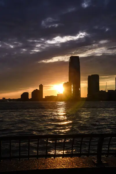 The Skyline of Jersey City in Silhouette, seen from the Battery Park at Sunset - Manhattan, New York City