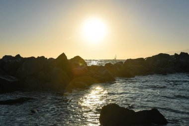 Bir yelkenli Venedik Sahili 'nin Rocky Sahillerinin ötesinde Sunset, Los Angeles, Kaliforniya