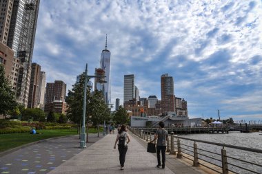 İnsanlar Hudson Nehri Parkı 'nda, New York, Manhattan' daki One World Trade Center 'da geziniyorlar.