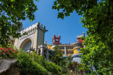 Yeşillik tarafından çerçevelenen Pena Sarayı 'nın (Palacio da Pena) canlı cephesi - Sintra, Portekiz
