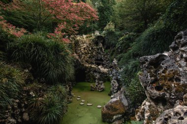 Quinta da Regaleira 'nın Grotto' sundaki Gizemli Yeşil Göl ve Taş Köprü Sintra, Portekiz