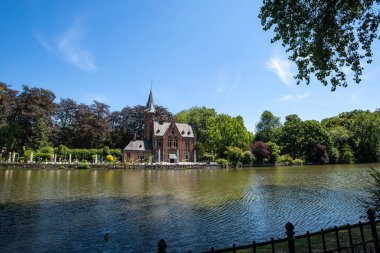 Güneşli bir günde Aşk Gölü 'nün yanındaki Minnewater Şatosu - Bruges, Belçika