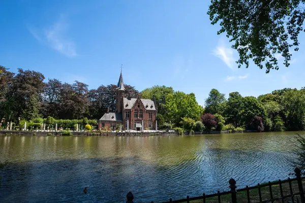Güneşli bir günde Aşk Gölü 'nün yanındaki Minnewater Şatosu - Bruges, Belçika