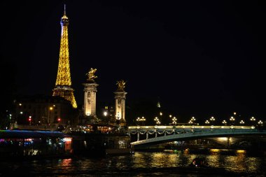 Eiffel Kulesi ve Pont Alexandre III 'ü Paris, Fransa' da, Seine Nehri üzerinde aydınlattı.