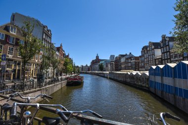 Yüzen Çiçek Pazarı (Bloemenmarkt) ve Büyüleyici Kanal boyunca uzanan Geleneksel Hollanda Binaları - Amsterdam, Hollanda