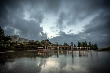 Reflective Waters of Jardim Amalia Rodrigues under Moody Skies - Lisbon, Portugal clipart