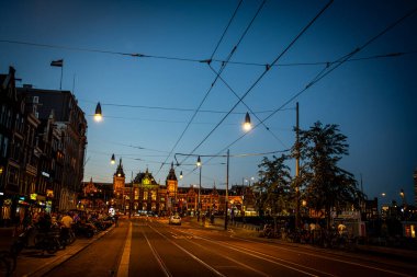 Damrak Caddesi Görünümü Centraal İstasyonu 'na bakıyor Dusk - Amsterdam, Hollanda