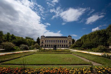 Manicured Gardens of Jardin des Plantes with Gallery of Evolution (Galerie de l'Evolution) - Paris, France clipart