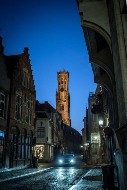 Wollestraat 'tan gece görüşü ve arka planda çan kulesi - Bruges, Belçika
