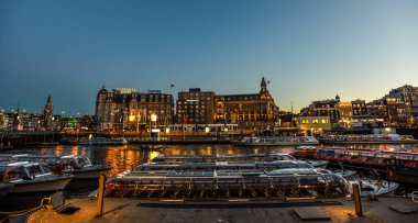Damrak Rıhtımı 'na yanaşan Kanal Tekneleri Akşam Manzarası - Amsterdam, Hollanda