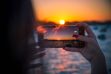 Brezilya 'da Akıllı Telefonlu Günbatımı Fotoğrafı Çeken Kadın