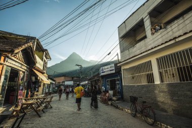 Vila do Abraao, Ilha Grande, Brezilya 'da bir kaldırım taşı caddesinde yürüyen insanlar.