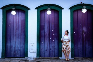 Paraty, Brezilya 'da Mor Koloni Kapıları Arasında Duran Genç Kadın