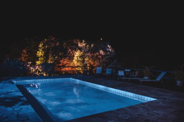 Itaipava, Brezilya 'da Gece Renkli Ağaç Işıkları ile Aydınlatılmış Havuz ve Salon Bölgesi