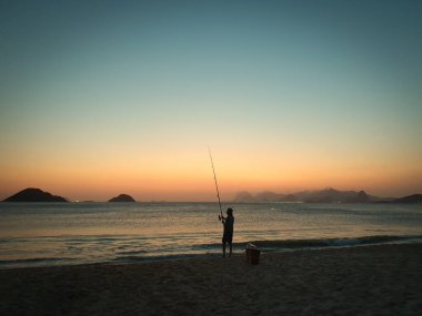 Balıkçı Silhouetted at Dusk on Itaipu Beach, Niteroi - Rio de Janeiro, Brezilya