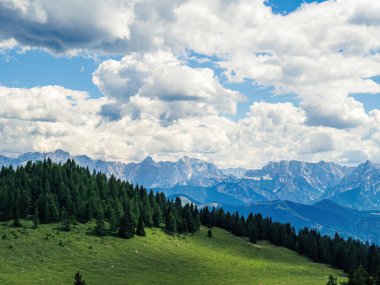 Karinthia, Avusturya ve Dobratsch 'tan gelen Julian Alpleri' nin ormanları ve dağlarıyla bulutlu yaz manzarası