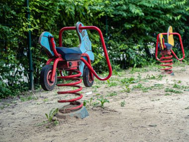 Mavi motosiklet ve sarı at bahar oyuncakları Kumlu yeşil bir banliyöde