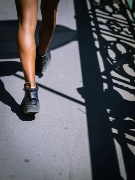 stock image Young black african american hispanic woman walking in leather boots from behind cropped legs only