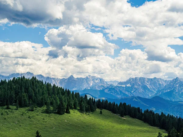 Karinthia, Avusturya ve Dobratsch 'tan gelen Julian Alpleri' nin ormanları ve dağlarıyla bulutlu yaz manzarası