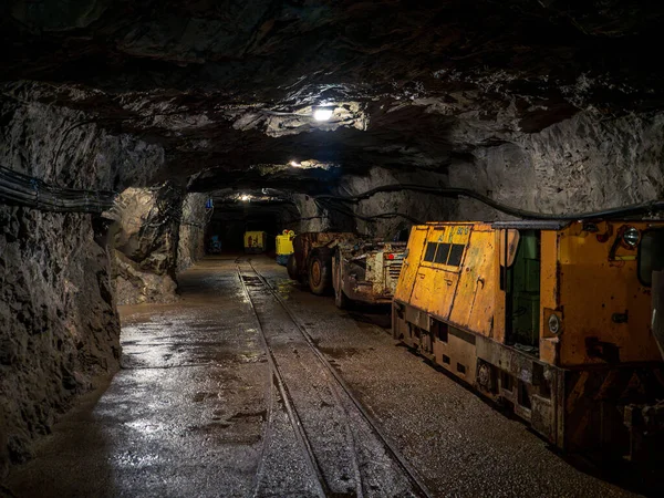 Mining equipment train tractor yellow machines engines in a subterranean underground coal mine tunnel