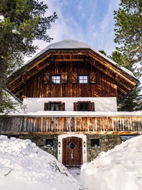 Kış karı sırasında geleneksel bir Alp köyü evinin önden görünüşü, Carinthia, Avusturya