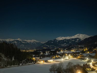 Gece manzarası Alplerde yıldızlı gökyüzü, vadide sokak ışıkları ve köyler, Millstatter See, Carinthia, Avusturya