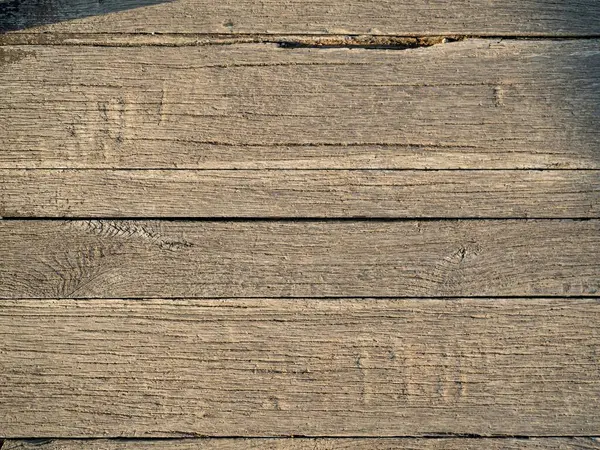 Old weathered damaged rustic vintage wooden flooring panel texture for background, soft golden hour light