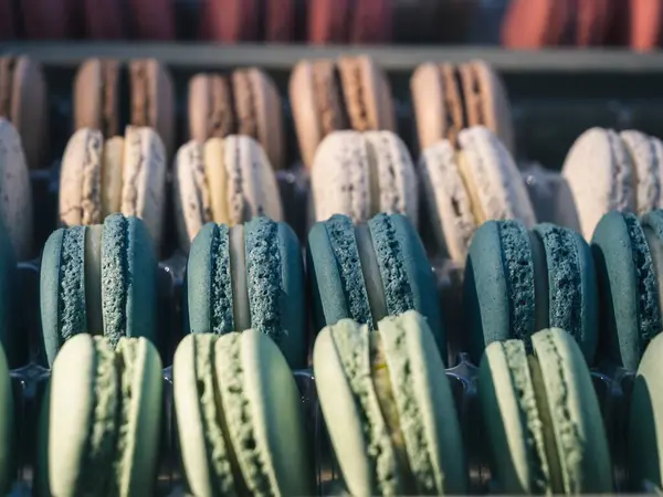 An assortment of colorful macaroons in a display box with selective focus bokeh background