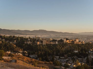 Granada, Endülüs, İspanya 'daki Alhambra kalesinin panoramik manzarası, gün batımında, Mirador de la Cruz de Rauda' dan, altın saat, açık gökyüzü, güneş ışığı