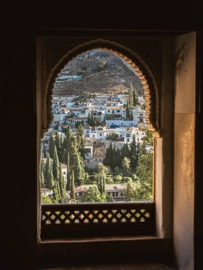 İspanya 'nın Granada şehrinin Albayzin bölgesinin görüntüsü, Alhambra Sarayı' nın kemerli penceresinden, yaz, güneş, oyulmuş taş, Endülüs