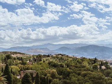 View of the Palace Gardens and the Sierra Nevada mountain range in Granada, Andalusia, Spain, summer vacation travel destination, panoramic view clipart
