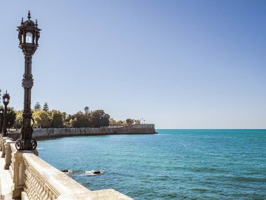 City walls with the bastion Baluarte de la Candelaria and the park of Alameda Apodaca in the Old Town of Cadiz, Spain, Andalusia, during summer, sea view, Atlantic ocean clipart
