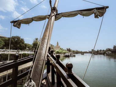 Torre del Oro adlı Ortaçağ kale kulesi Guadalquivir nehri, Endülüs, İspanya 'daki tarihi kopya gemisi Nao Victoria' dan görülmektedir.