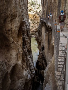 El Chorro, İspanya, 15 Eylül 2023: Endülüs, Malaga, İspanya 'daki El Caminito del Rey vadisindeki geçitte yürüyen turistler