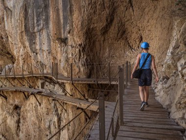 Endülüs, Malaga, İspanya 'daki El Caminito del Rey vadisindeki eski harabe yolda yürüyen genç bir bayan turist.