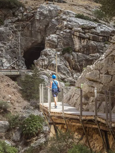 stock image A young female woman girl tourist walking on the walkway at the gorge canyon of the El Caminito del Rey in Andalusia, Malaga, Spain