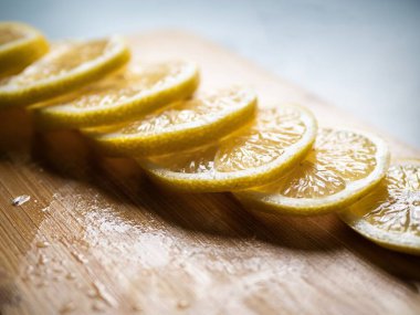 Dilimlenmiş bir limon bambu ahşap bir tahta üzerinde açık mavi bir masa üzerinde, yumuşak ışıklandırma, fotokopi alanı, insan yok, yakın görüş