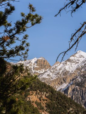 Briancon 'daki Serre Chevalier zirvesinin göz kamaştırıcı manzarası, açık mavi gökyüzüne karşı. Engebeli dağ manzarası kışın Fransız Alplerinin güzelliğini gözler önüne seriyor..