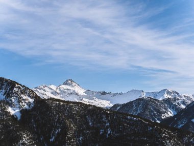 Briancon 'daki Serre Chevalier zirvesinin göz kamaştırıcı manzarası, açık mavi gökyüzüne karşı. Engebeli dağ manzarası kışın Fransız Alplerinin güzelliğini gözler önüne seriyor..