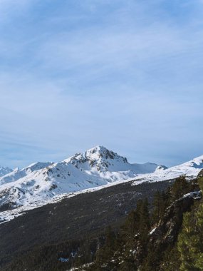 Briancon yakınlarındaki karla kaplı Fransız Alpleri 'nin sakin manzarası, yüksek tepeler ve yüksek yeşil çam ağaçları. Yumuşak pastel gökyüzü serin, görkemli dağ manzarasına sıcaklık katar..