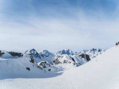 Serre Chevalier kayak bölgesinde yer alan Briancon 'daki karla kaplı dağların çarpıcı manzarası. Açık mavi gökyüzü bu popüler dağlık kışın güzelliğini arttırır..
