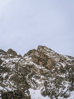 Briancon, Fransa 'da engebeli, karla kaplı bir dağ, sık yeşil ormanların üzerinde yükseliyor. Dramatik manzara kışın Fransız Alplerinin güzelliğini vurgular..