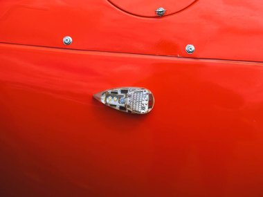 LED navigasyon ışığı ve metalik perçin içeren kırmızı bir uçak gövdesinin detaylı görüntüsü, modern havacılık tasarımı ve aerodinamiği vurguluyor..