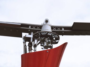 Helikopterin kuyruk pervanesi montajına yakın plan mekanik detaylar, dişliler ve cıvatalar sergileniyor. Mühendislik bileşenleri havacılık teknolojisini ve hassas mühendisliği vurguluyor..