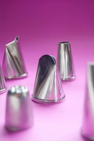 stock image Baking tools, variety of piping tips on a pink background